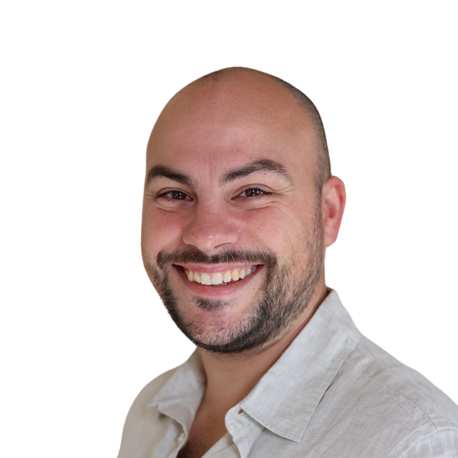 Portrait d'un homme chauve et barbu souriant.